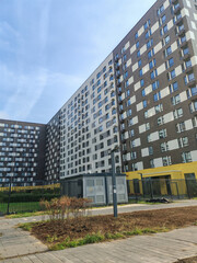 close-up of two apartment towers, one with a vibrant yellow and white facade, the other with a checkerboard pattern. The clean lines and bold colors symbolize modern city living and innovative design.
