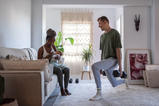 Multiracial family with baby at home - Powered by Adobe