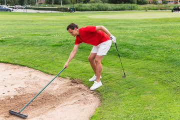 Man Cleaning Golf Bunker