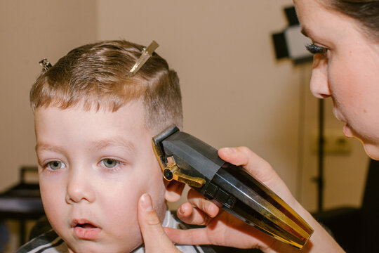 barber cuts a boy's hair