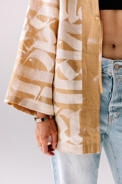 A model showcasing a yellow patterned kimono and denim jeans