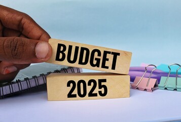 Budget 2025 text on wooden blocks with office stationery. Budgeting concept.