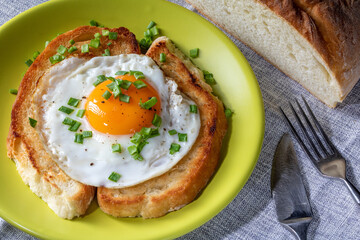Fried egg and croutons on kitchen table, top view