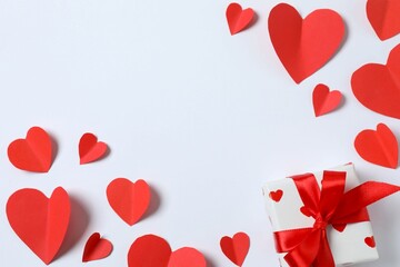 Beautiful gift box with red hearts on white background