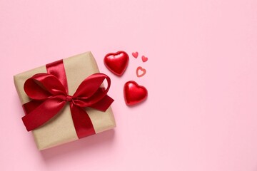 Beautiful gift box with red hearts and paper card on color background