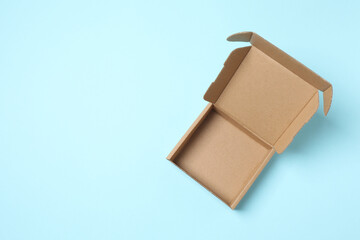 Open cardboard box on color background