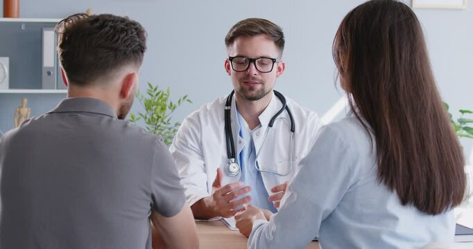 Doctor, reproductologist explaining young family couple reproductive health test, discussing medical results to husband, wife, planning long expecting childbirth together, parenthood medicine
