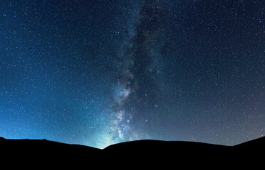 Beautiful bright milky way galaxy under the mountains. Night landscape.