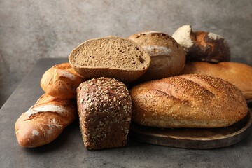 Different freshly baked bread loafs on grey table