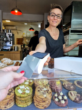 POV of woman paying contactless at cookie shop
