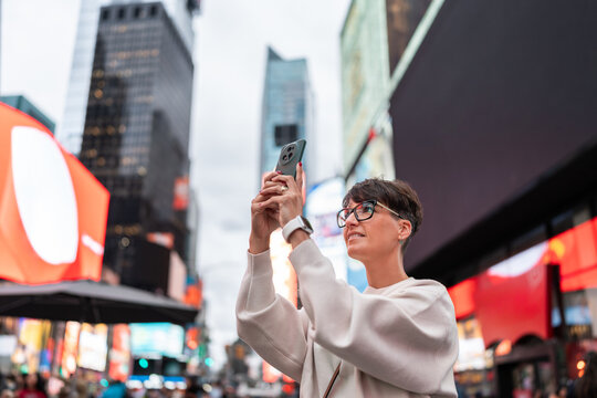 Tourist taking photos in times square, new york city