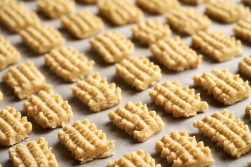Homemade raw Christmas cookies on parchment paper before baking