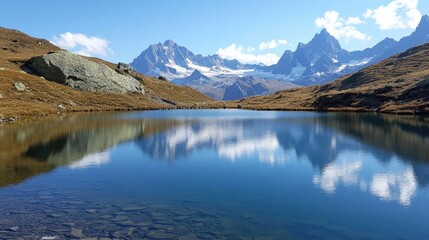 Tranquil lake reflecting majestic mountains under a clear blue sky in a picturesque alpine landscape