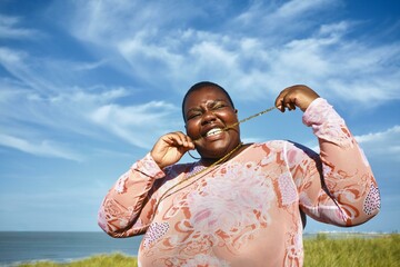 Joyful expression by the seaside on a sunny day biting gold