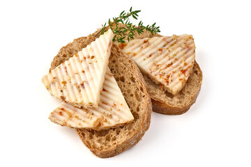 Seasoned cheese wedge with herbs and spices, isolated on white background.