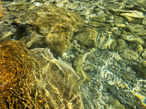 Stones and pebbles in sea crystal clear water.