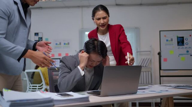 Corporate executive pointing finger at frustrated worker during tense meeting, displaying workplace conflict and professional stress dynamics