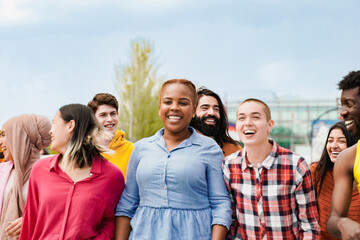 Group of people smile together in city street. Young friends having fun in travel vacations