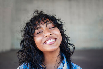 Happy Latin American young woman smiling in front camera