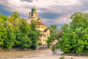 Das M&uuml;llersche Volksbad in M&uuml;nchen an der Isar unter dramatischem Wolkenhimmel