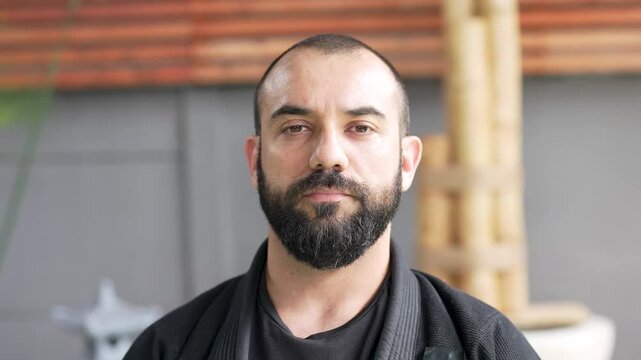 Martial arts master posing for camera in dojo, headshot portrait 