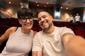 Happy couple taking a selfie in theater in manhattan, new york city
