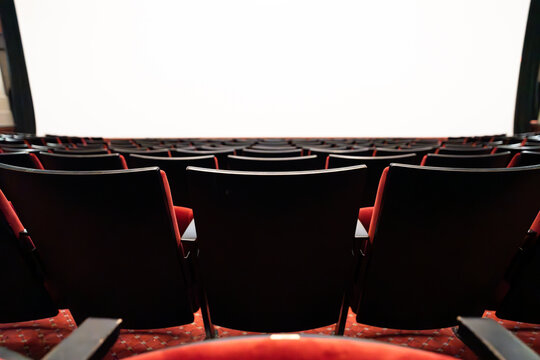 Empty cinema seats facing white projection screen in manhattan