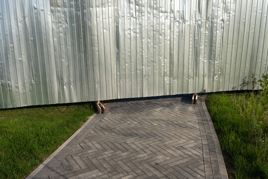 Corrugated Metal Fence with Paved Pathway
