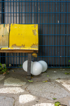 Yellow Bench with Balloons and Metal Fence