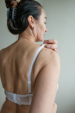 Mature woman putting on a bra