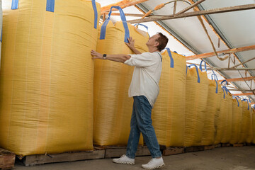 Senior Worker Engaged in Industrial Inspection of Large Storage Bags