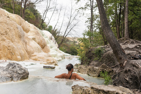 woman bathing in a natural hot spring in Tuscany, Italy