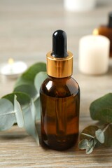 Eucalyptus essential oil in a glass bottle with green eucalyptus leaves on a wooden background. Aromatherapy concept. Spa. Natural organic ingredients for cosmetics and body care.