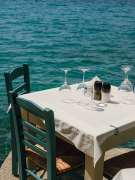 A serene seaside dining setup with clear turquoise waters