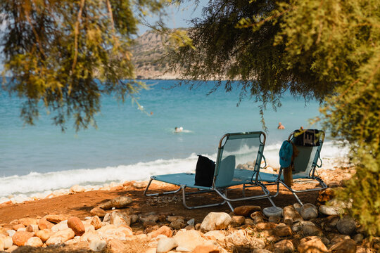 Relaxing on beach loungers by the blue sea on a sunny day 