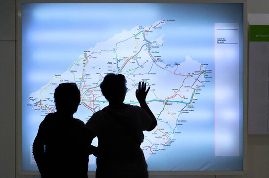 Tourists exploring a public transport map of Mallorca