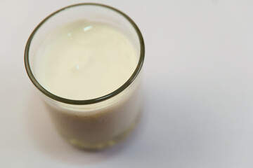 A glass of milk is sitting on a white table