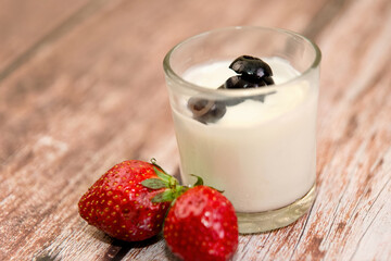 Creamy Yogurt with Black Olives and Strawberries on Wooden Surface