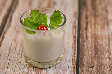 Cherry Tomato on Creamy White Dessert with Cilantro Garnish