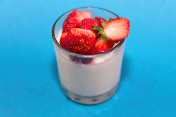 Fresh Strawberries on Creamy Dessert in Glass on Blue Background