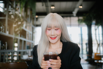 woman with long white hair enjoys drink in cozy e setting