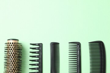 Professional combs and hairdresser tools on color background, top view