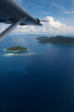 Wing view flying over tropical Islands in Indonesia.
