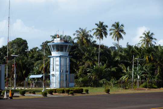 Small airport control tower surrounded by tropical vegetation,