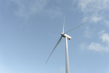 Wind turbine generating clean energy under blue sky