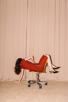 Unique Artistic Pose of Woman on Office Chair