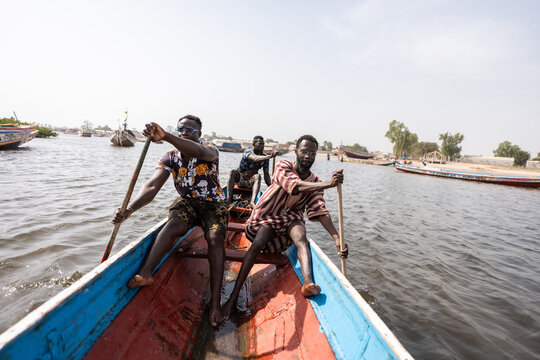 Fishermen rowing pirogue in delta saloum, senegal