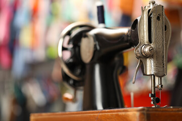 One vintage sewing machine in workshop, closeup. Space for text