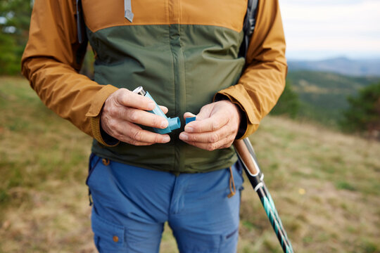 Man carries an inhaler spray on a mountain
