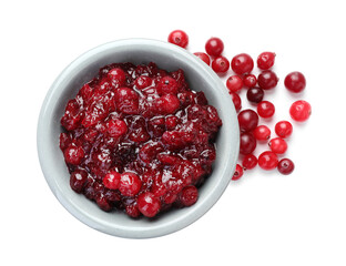 Tasty cranberry sauce in bowl and berries isolated on white, top view